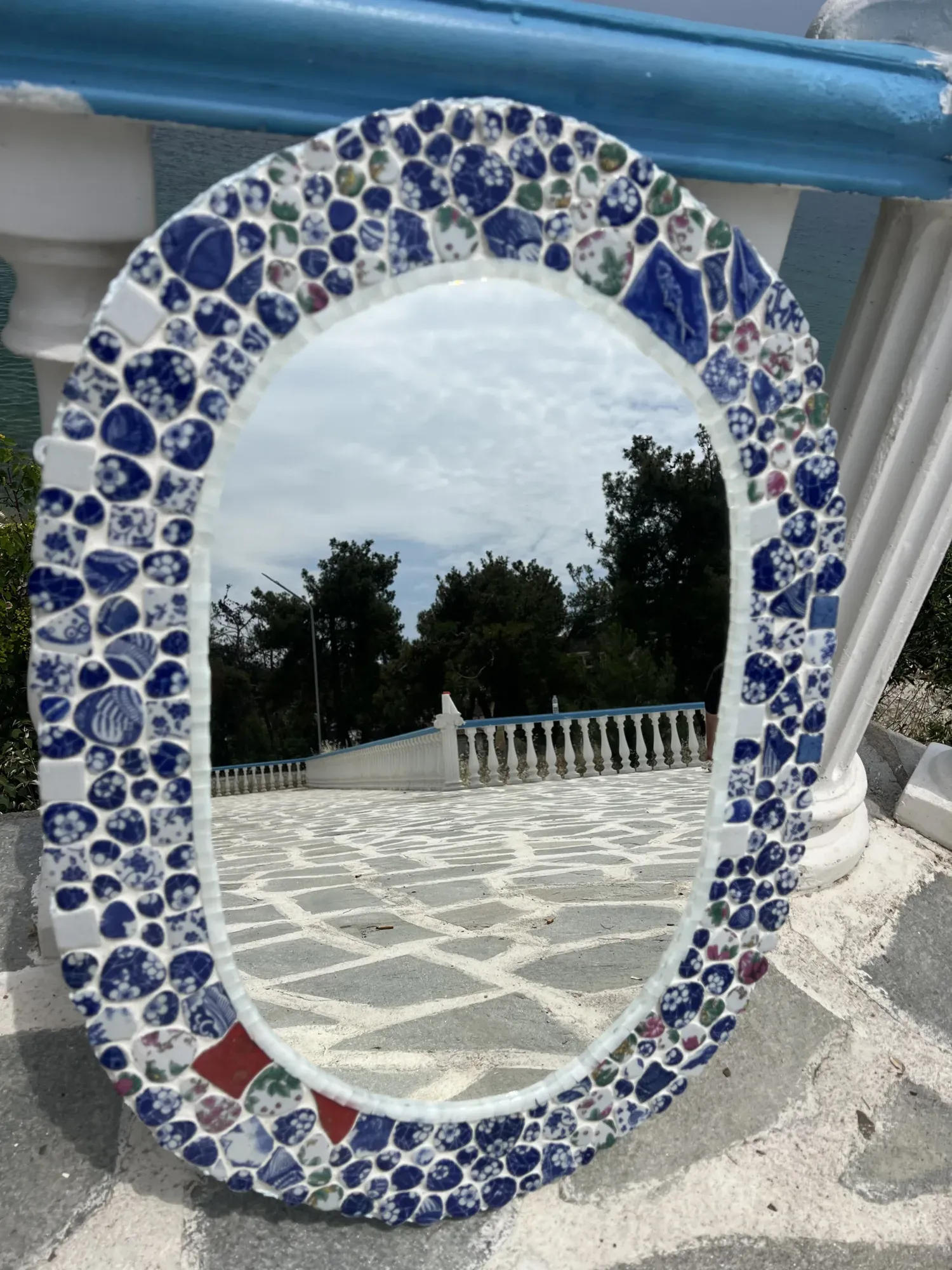 Kyma upright, trees reflected, red shards in the porcelain border