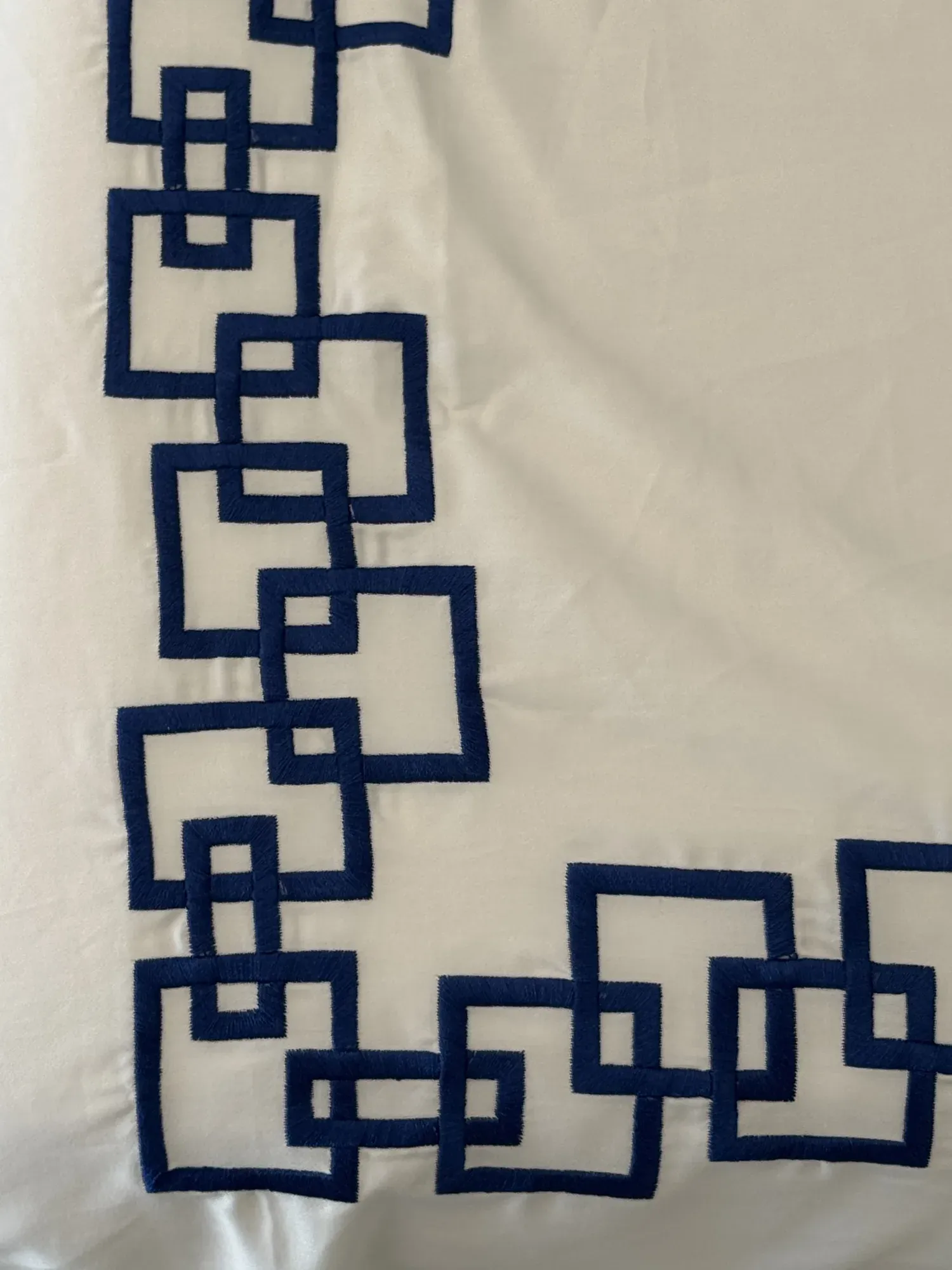Close view of the embroidered navy chain at the corner of a Desmos sheet