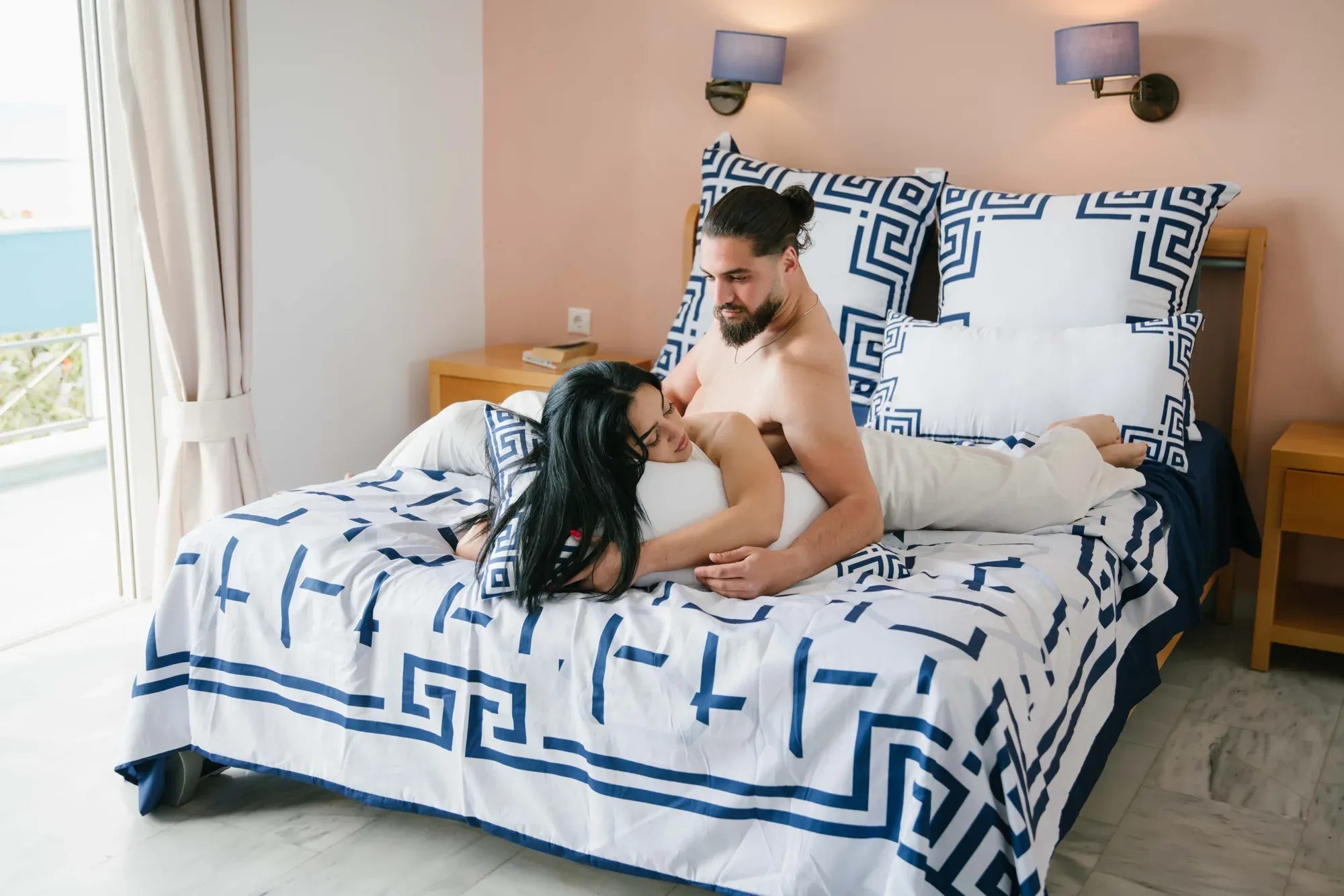 A couple raising glasses on an Ionian Harmony bed