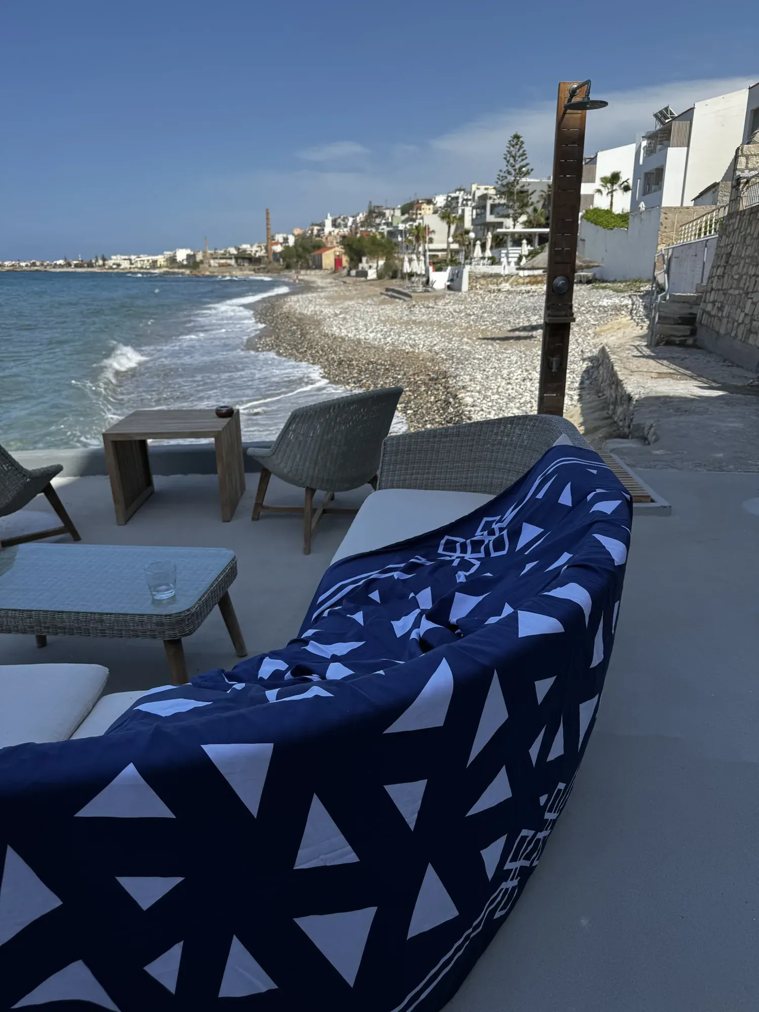 Mythos Tides spread on the rocks by the sea with a clay pot